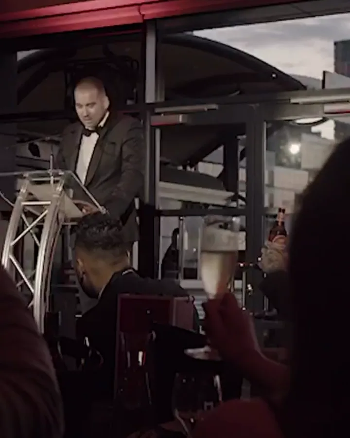 An example acceptance film: the winner at the lectern on the night, the room raising a glass.