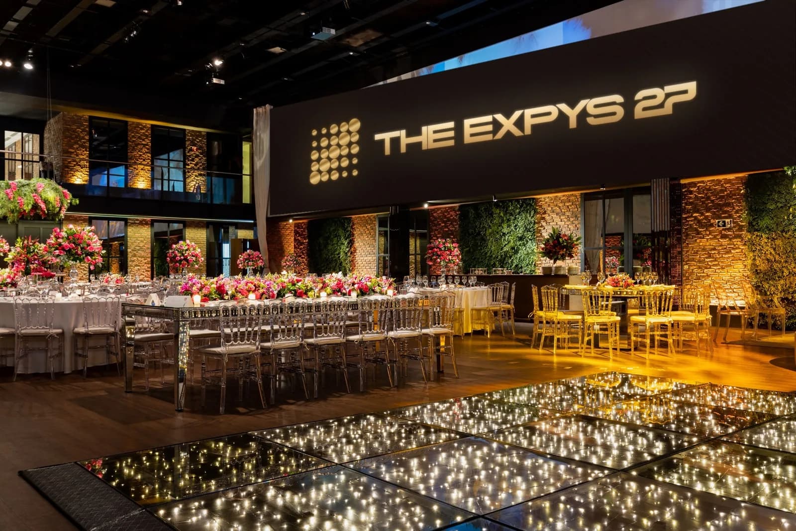 A dining room under a long projection band showing THE EXPYS 27