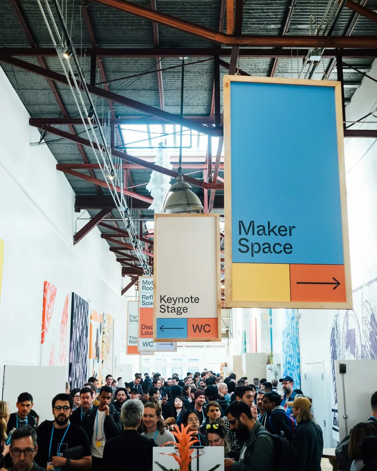 A maker space sign above a crowded hall