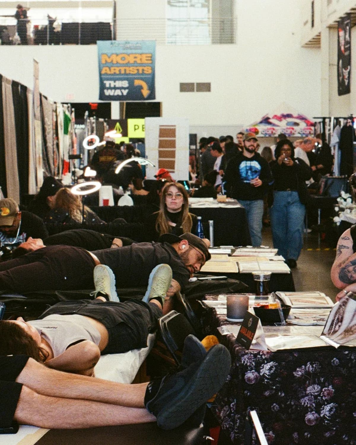 Artists tattooing at a convention floor